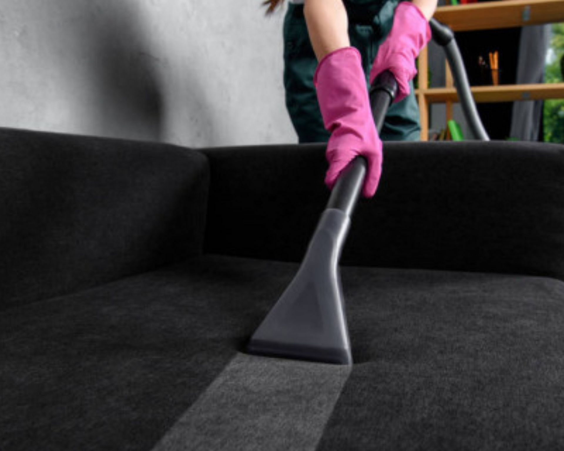 Spacious living room with gray sofa, beige chairs, and large windows overlooking the water.