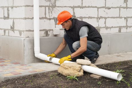 male worker fixing the gutter pipe