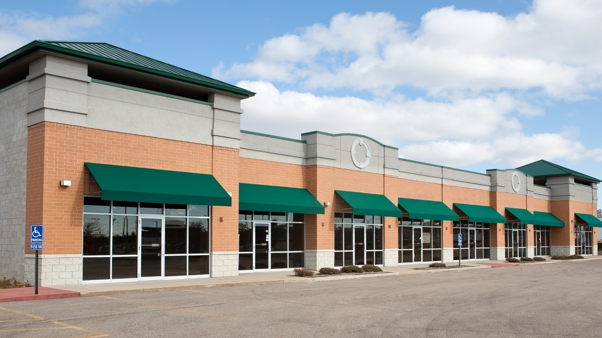 A man and a woman are shaking hands in front of a model house.