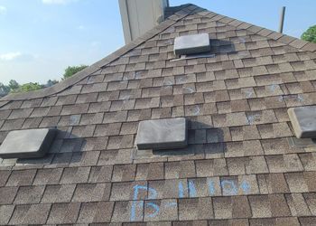 A close up of a roof with a few vents on it.