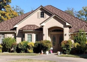 A large brick house with a brown roof