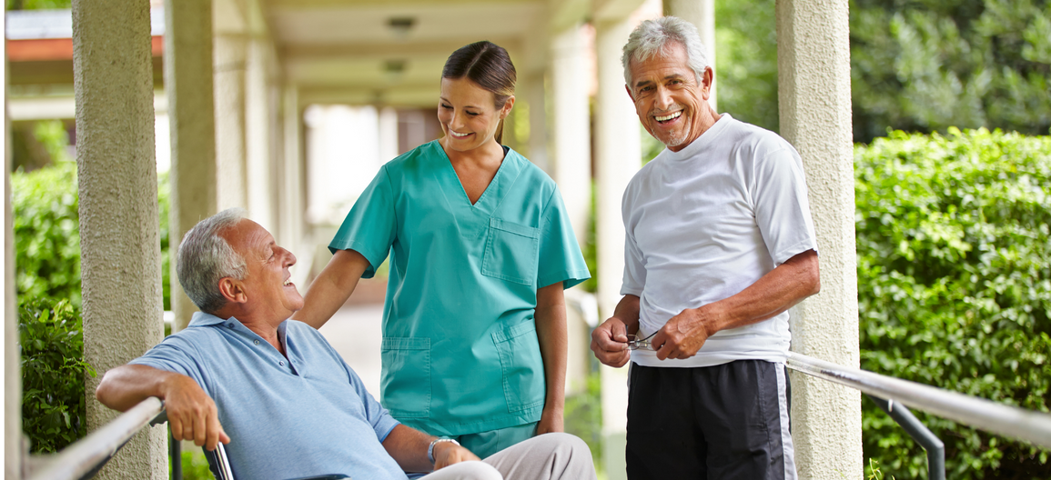 A nurse is talking to an elderly man in a wheelchair.