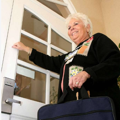 A woman in a black sweater is holding a blue bag