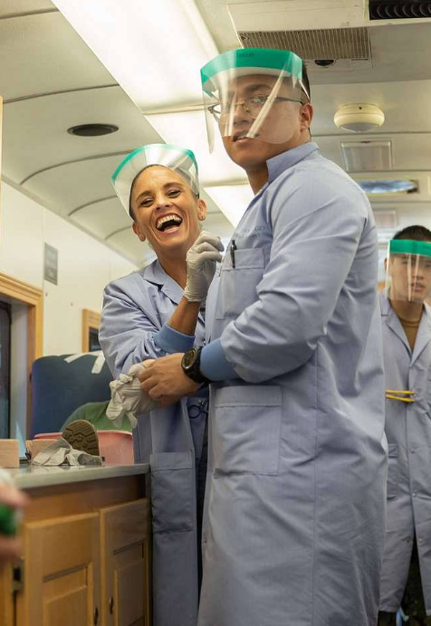 A man and a woman wearing face shields are standing next to each other.