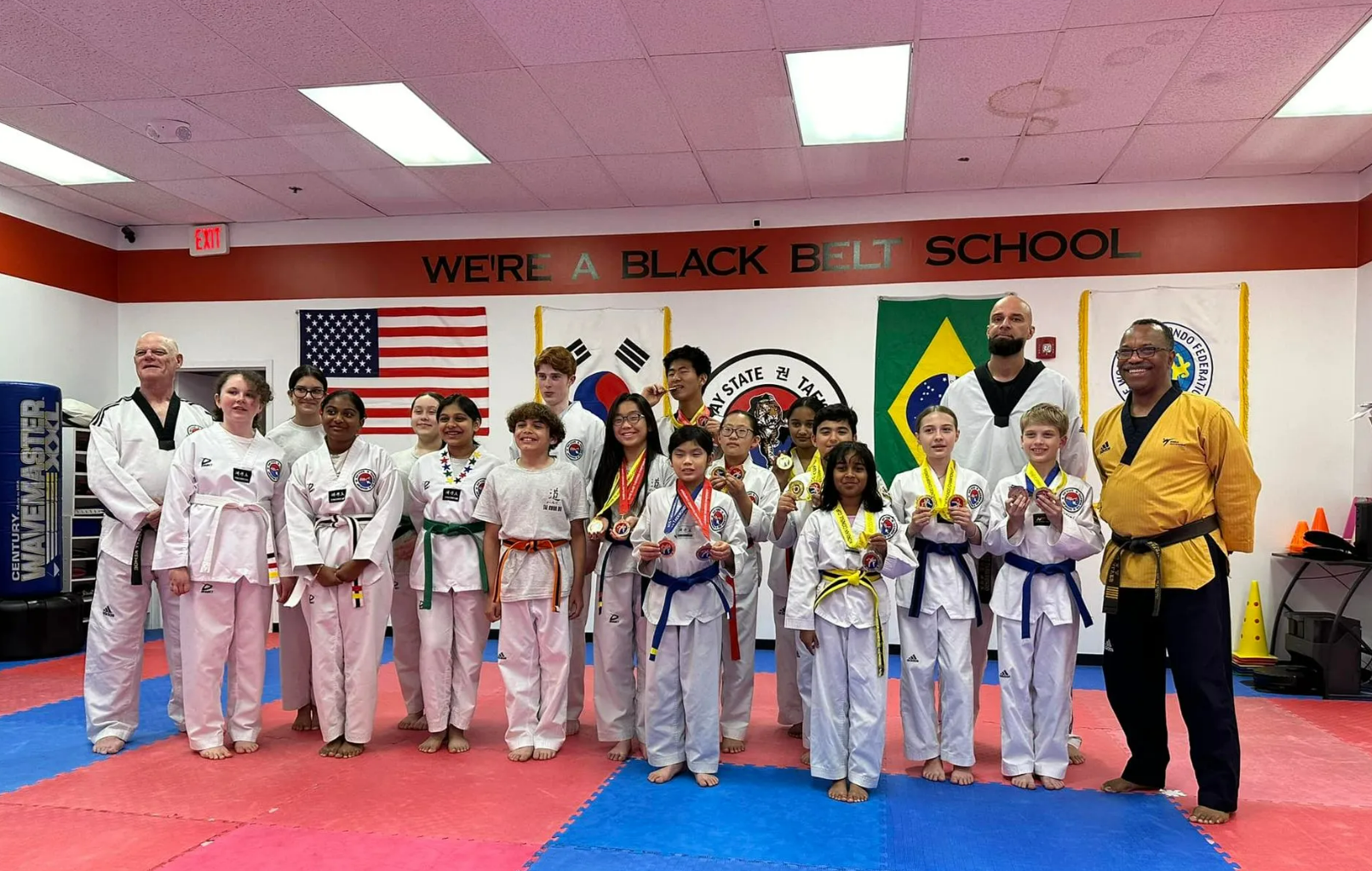 A group of people are posing for a picture in a gym.