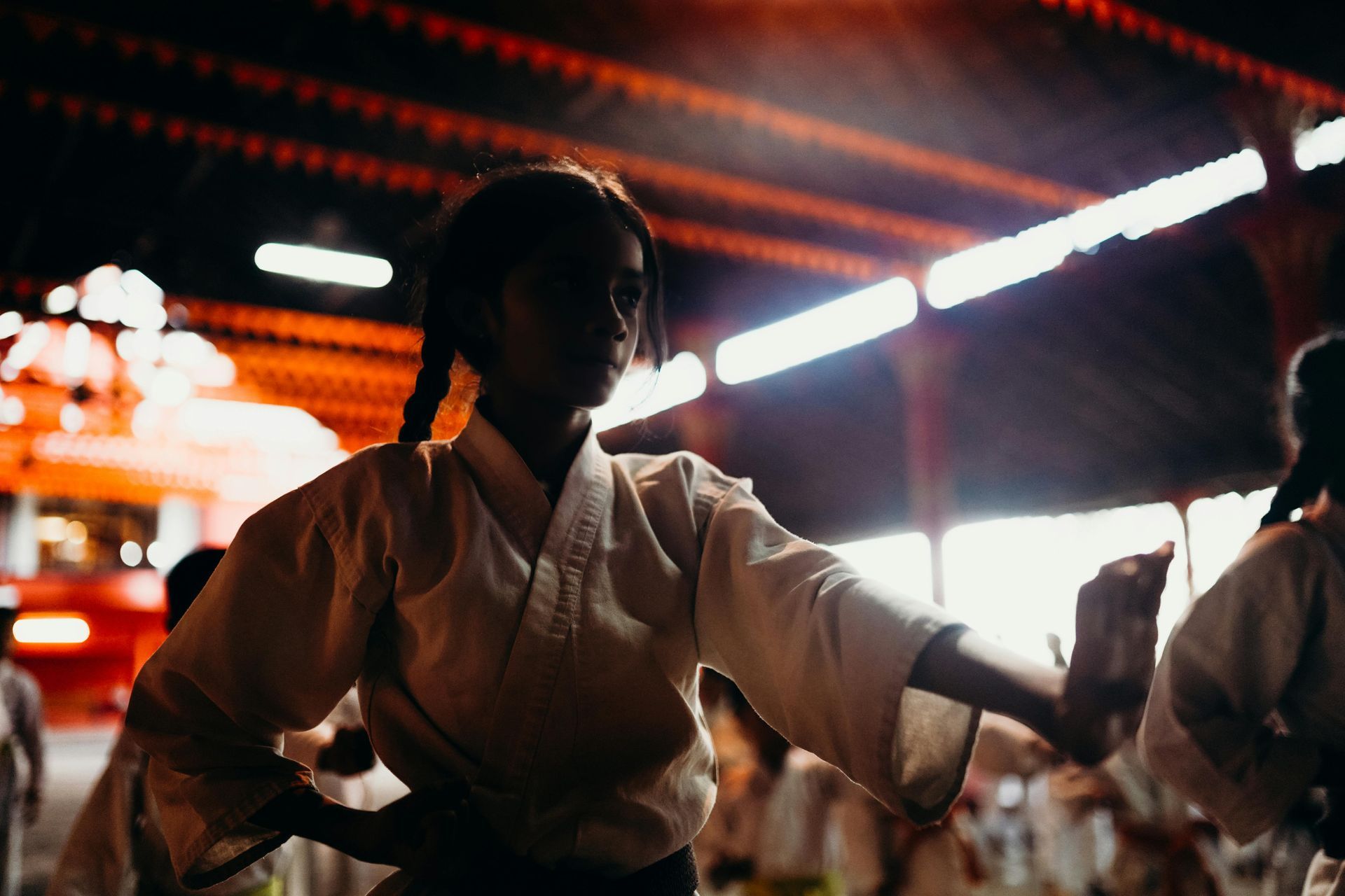 A group of people are practicing karate in a dark room.