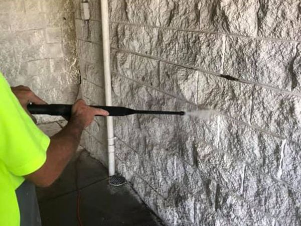 Worker Spray Painting On Wall — Classic Coatings Australia In Wondunna QLD