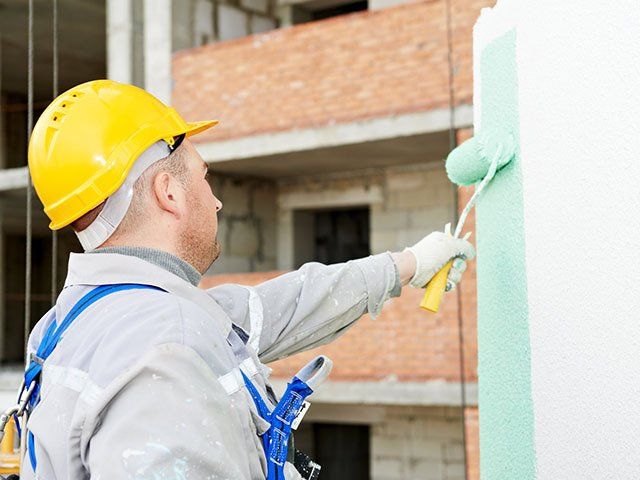 Worker Painting Facade Of High Rise Building — Classic Coatings Australia In Hervey Bay QLD