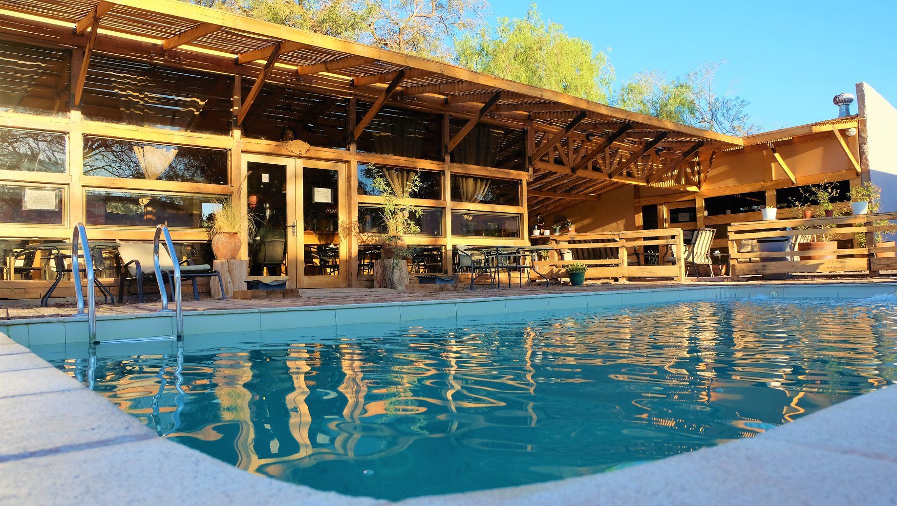 Una gran piscina con un edificio de madera al fondo.
