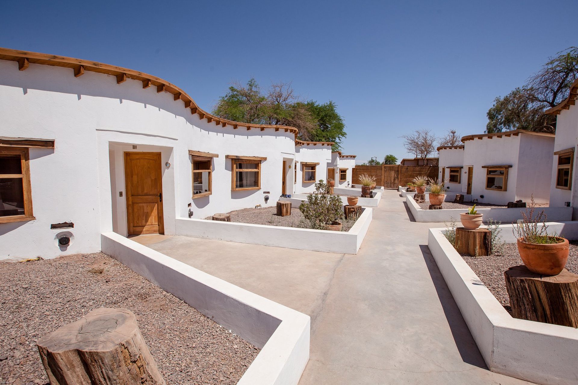 Una hilera de casas blancas con puertas y ventanas de madera.