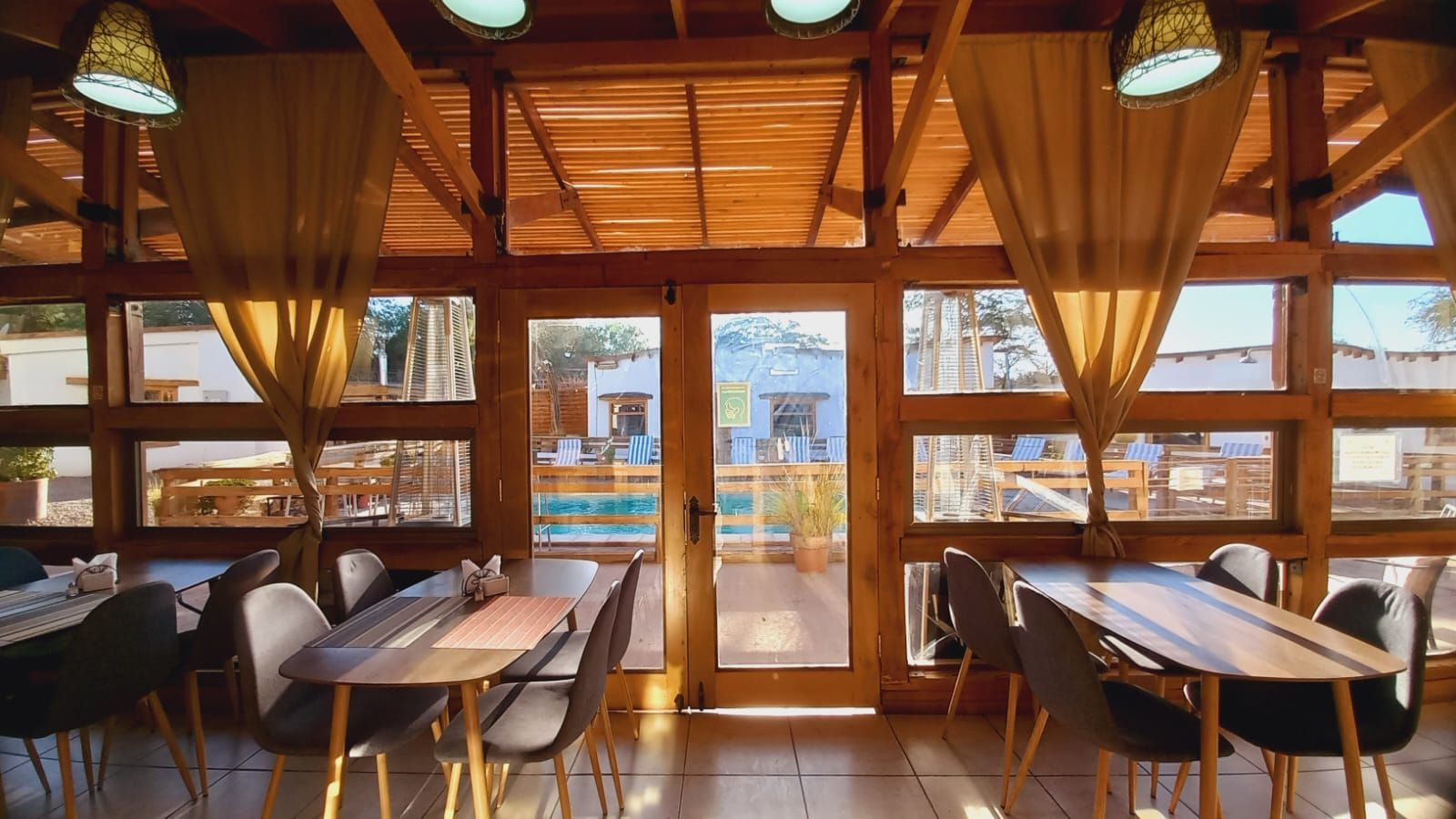 Un restaurante con mesas y sillas y muchas ventanas.