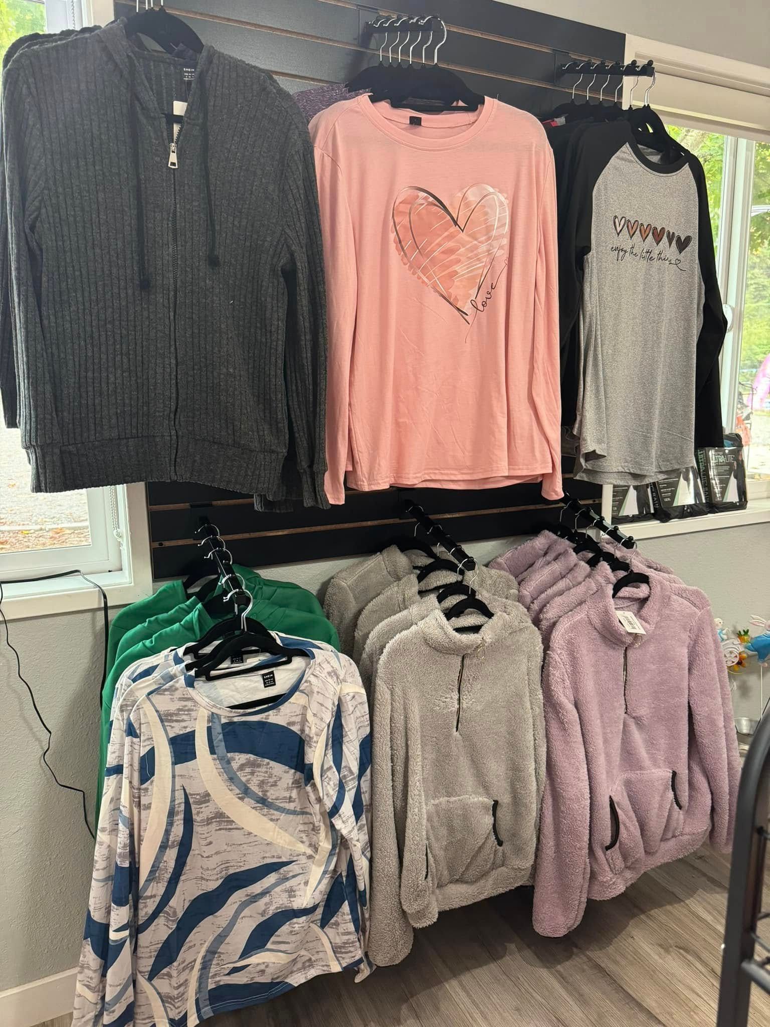 A bunch of clothes are hanging on a wall in a store.