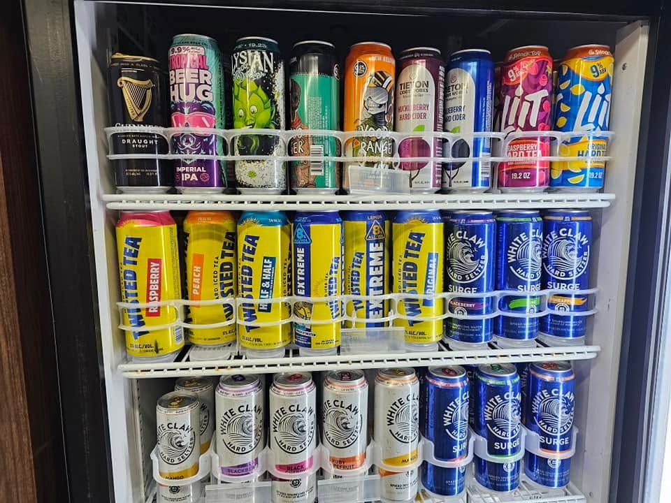 A refrigerator filled with a variety of canned beverages.