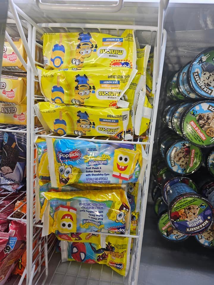 A shelf filled with bags of spongebob ice cream in a store.