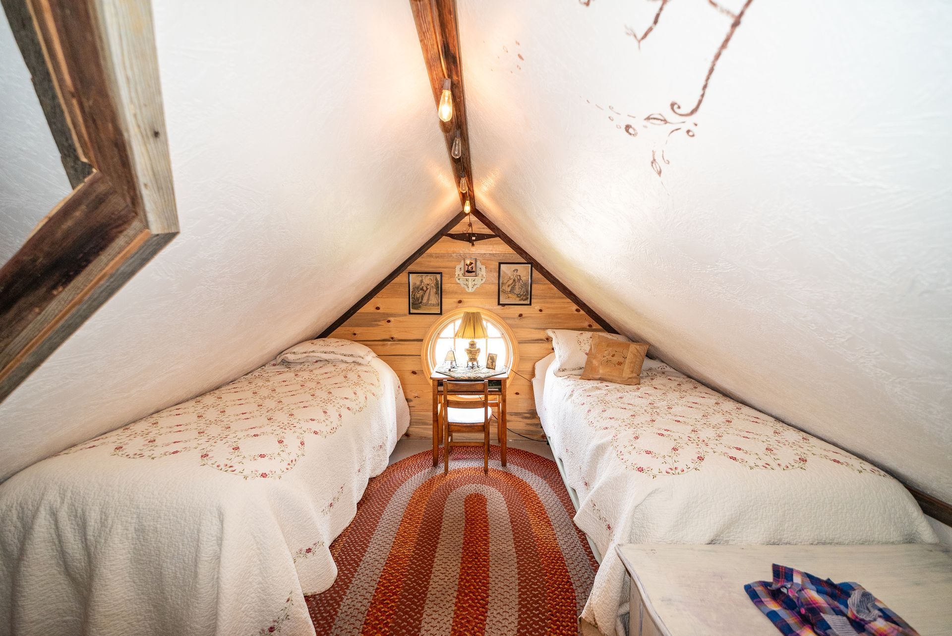 A bedroom featuring a large wooden four-poster bed with a green spread, a patterned rug, a chair, and a dresser.