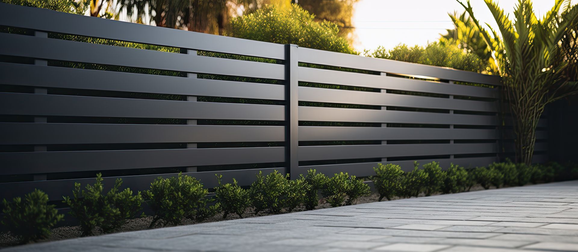 A black fence is surrounded by bushes and trees