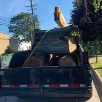 A truck bed loaded with large, rough rocks. The vehicle is parked outdoors, likely for transport.