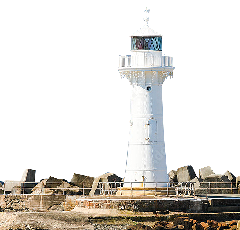 A white lighthouse is surrounded by rocks and a fence.