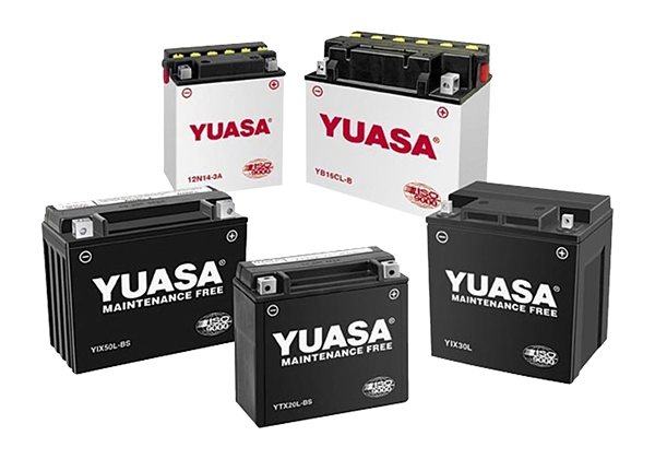 A group of yuasa batteries are sitting on top of each other on a white surface.