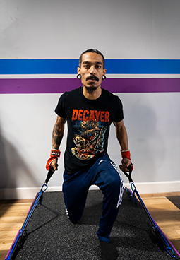 A man is doing exercises with resistance bands in a gym.
