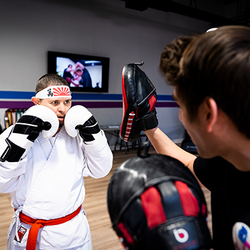 A person wearing boxing gloves with the letter b on them