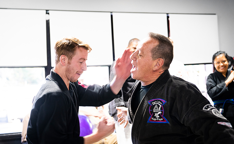 Two men are giving each other a high five in a room.