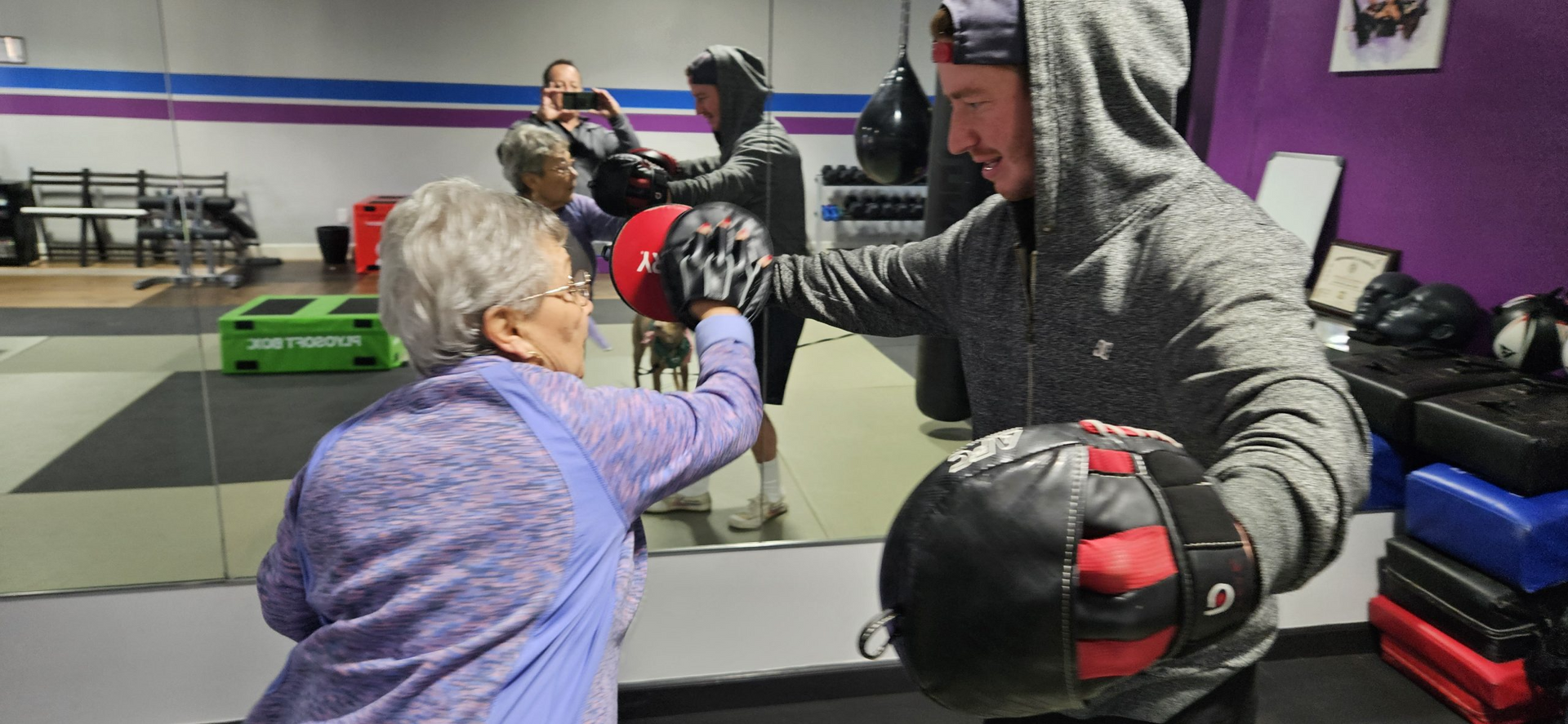 A man and a woman are boxing in a gym.