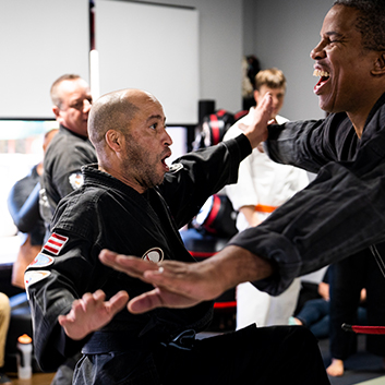A group of men are practicing martial arts in a gym.