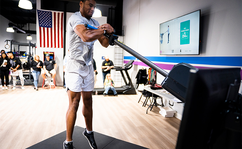 A man is swinging a barbell in a gym.
