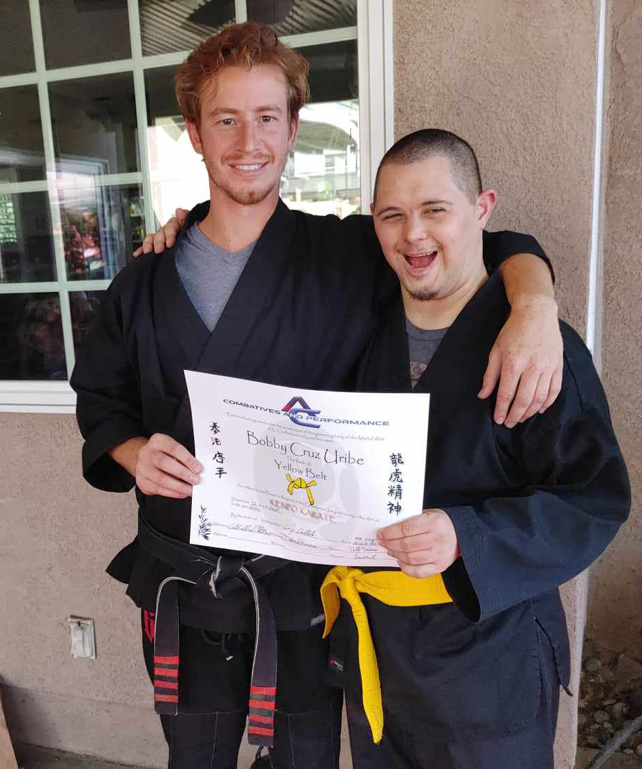 Two men are posing for a picture and one is holding a certificate