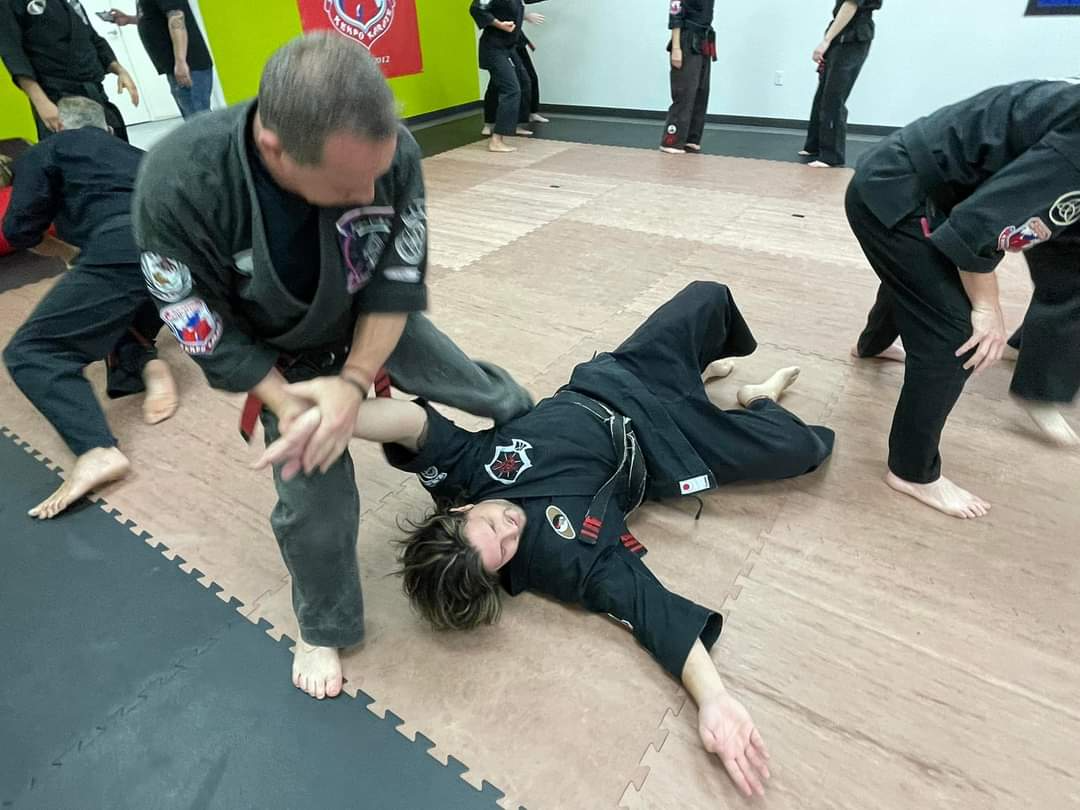 A group of people are practicing martial arts in a gym.