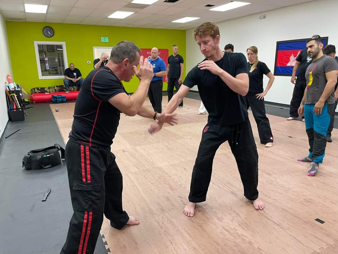 A group of men are practicing martial arts in a gym.