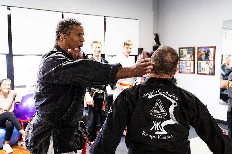 A group of men are practicing martial arts in a gym.