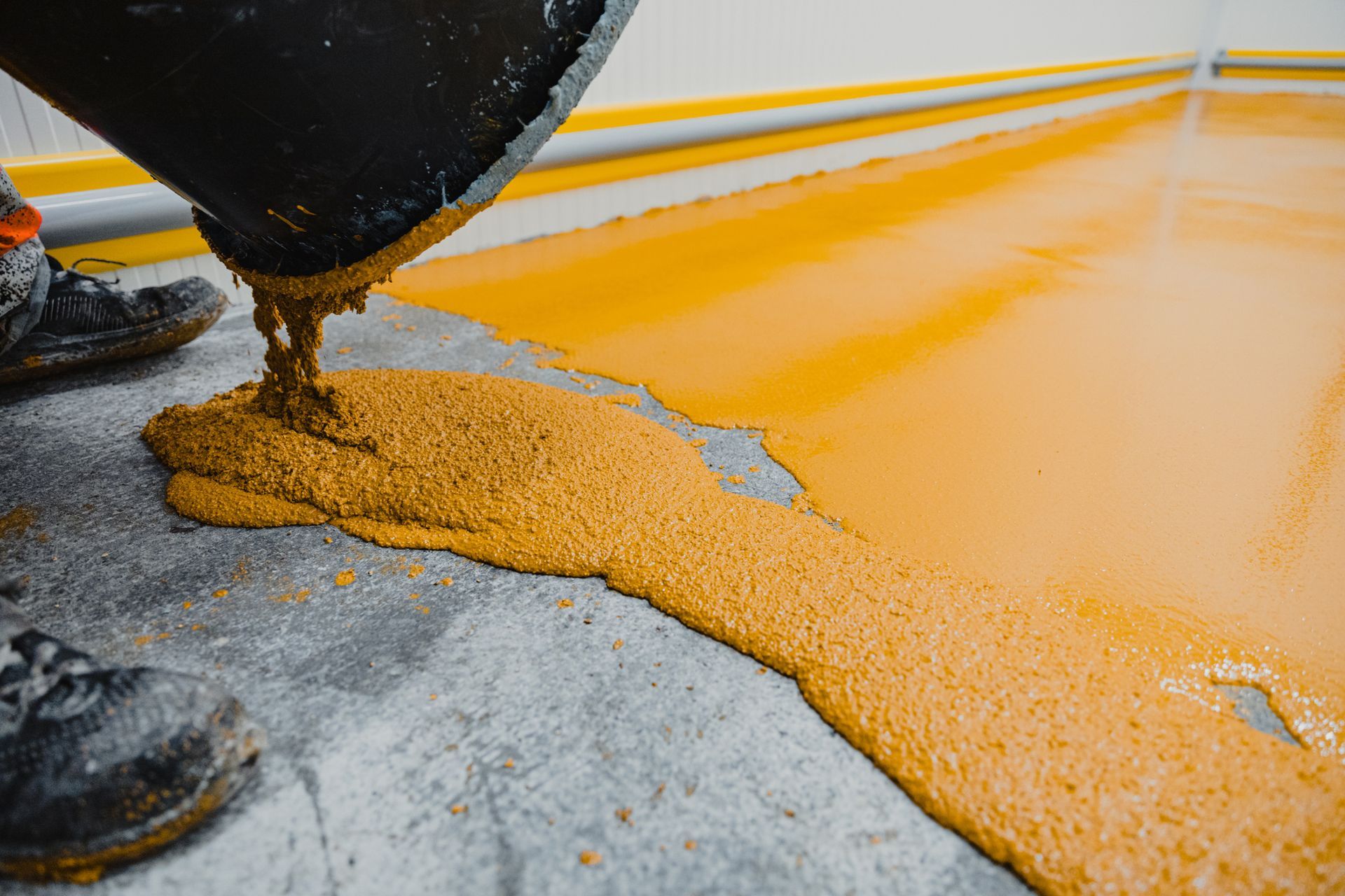 Person Pouring Yellow Liquid To Concrete Floor – Oak Lawn, IL – Dana Decorative Concrete Inc