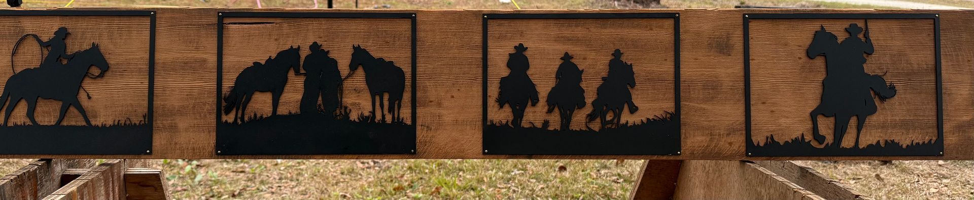 Wooden fence panels with cowboy silhouettes. Depictions include a cowboy roping a horse, cowboys wrangling, and a cowboy riding.