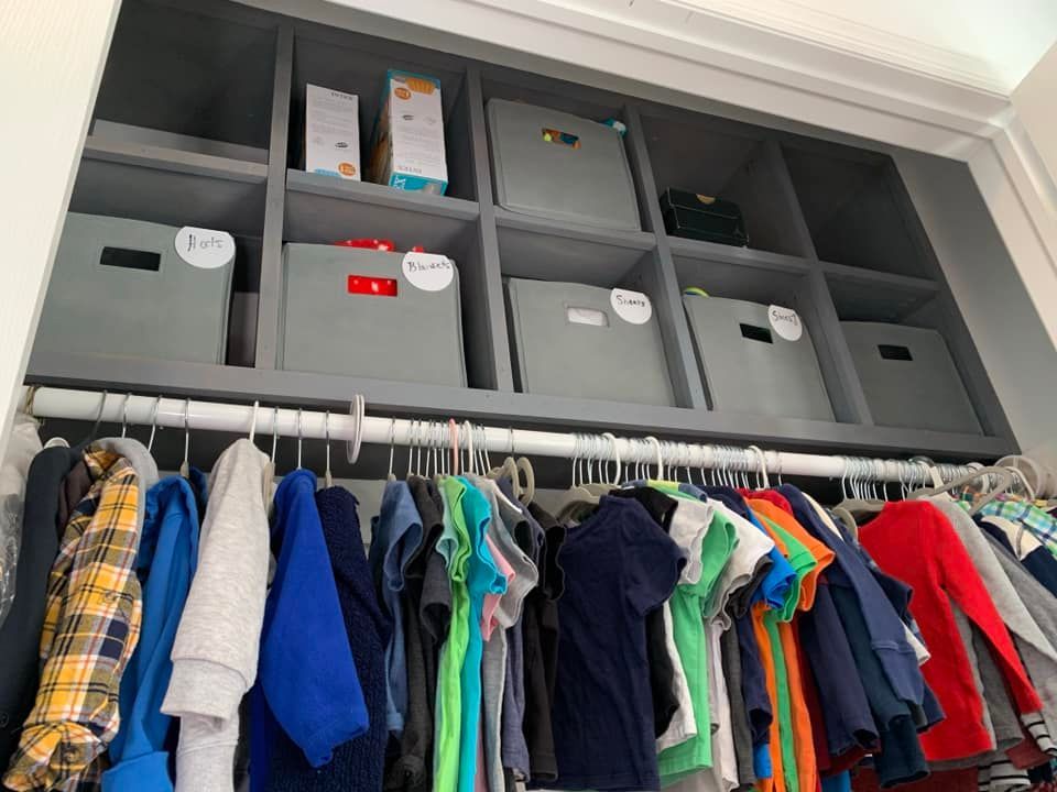 A closet filled with lots of clothes and boxes.