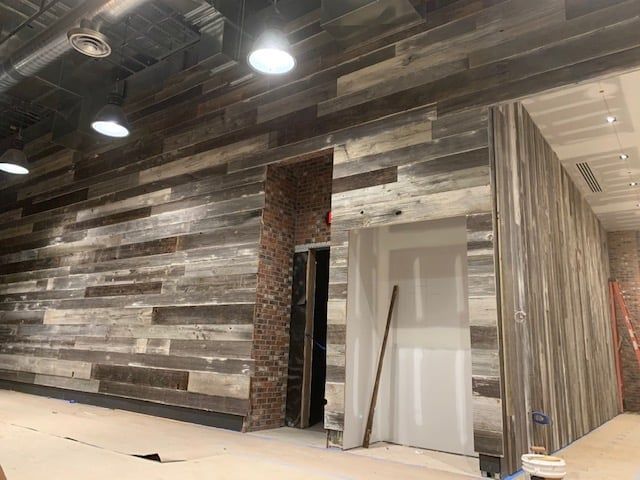 A room with a wooden wall and a door.