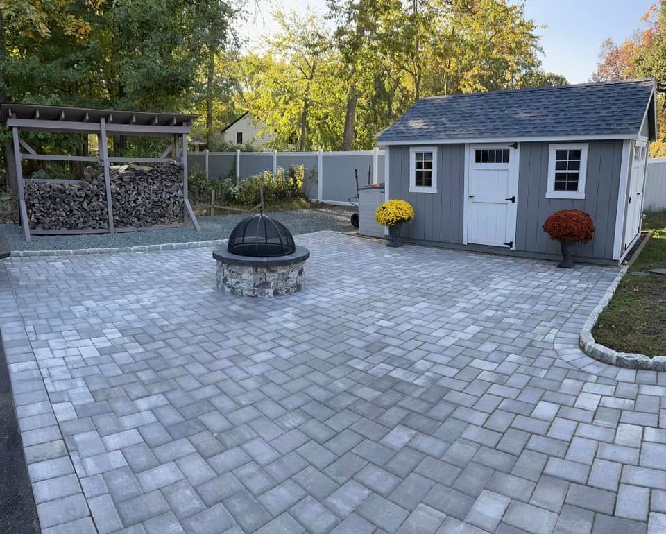 A backyard with a fire pit and a shed.