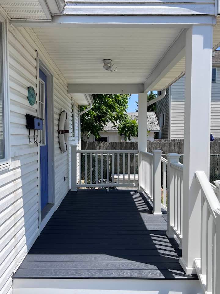 A white house with a blue door and a porch
