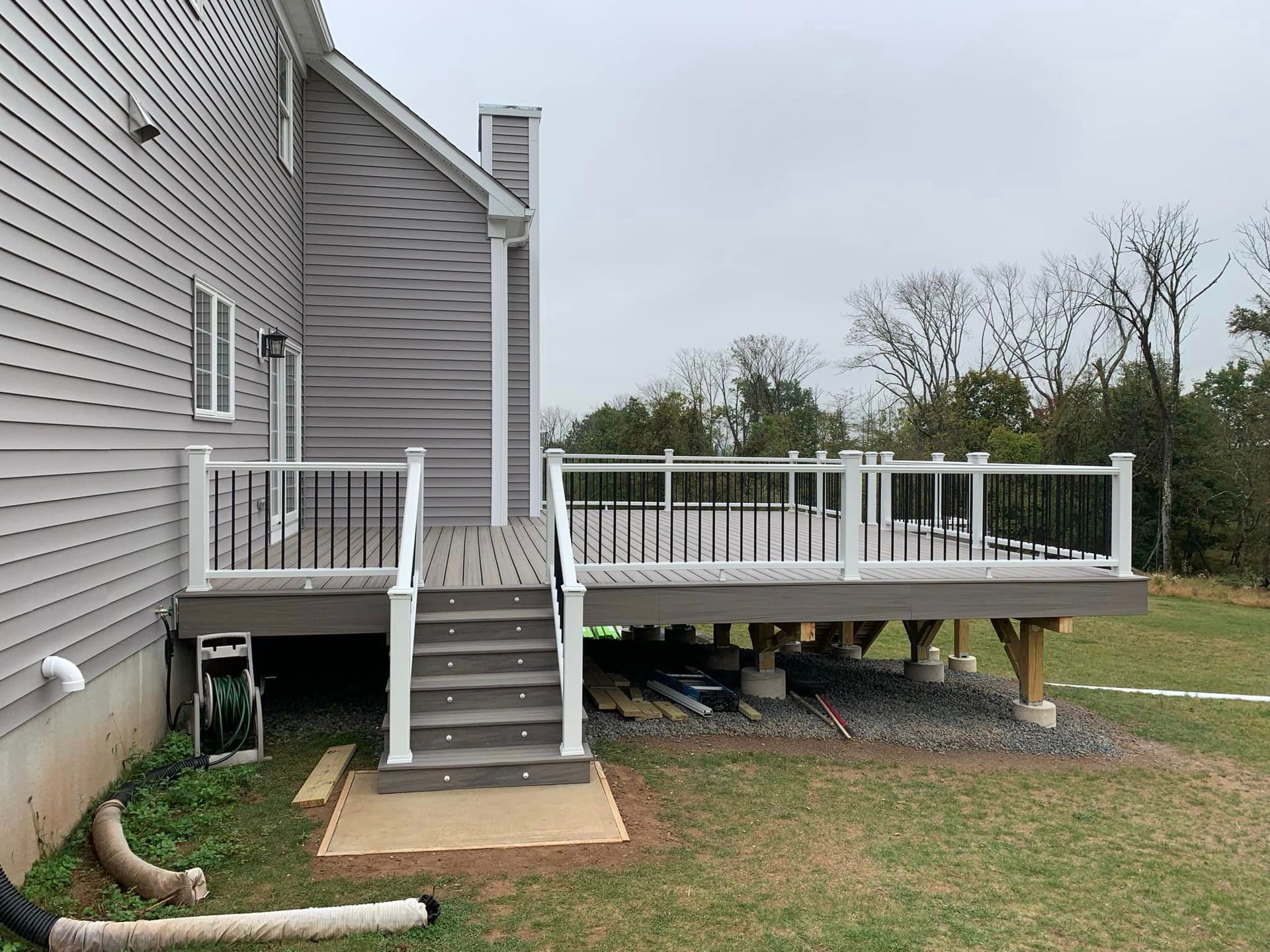 A large deck with stairs is being built in the backyard of a house.