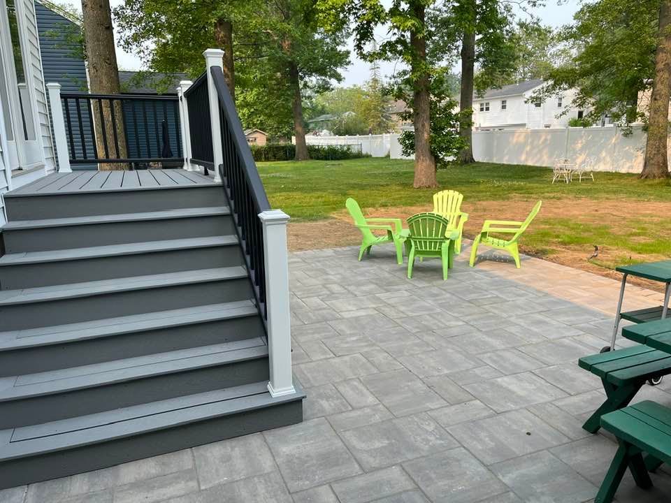 A patio with stairs , chairs , and a picnic table.