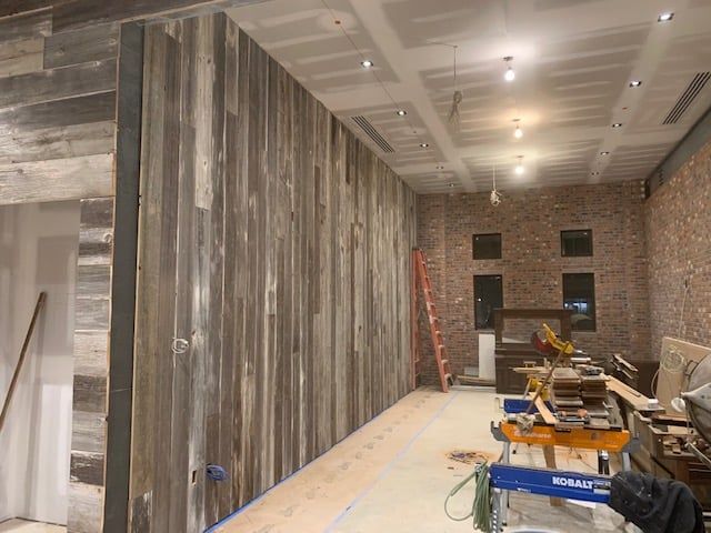 A room with a wooden wall and a ladder in it