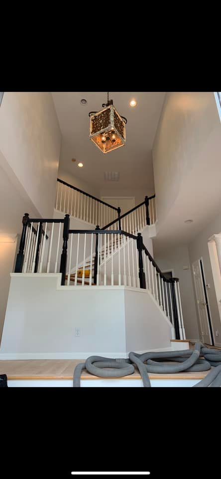 A picture of a staircase in a house with a chandelier hanging from the ceiling.