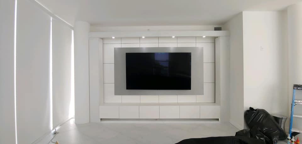 A living room with a flat screen tv on the wall.