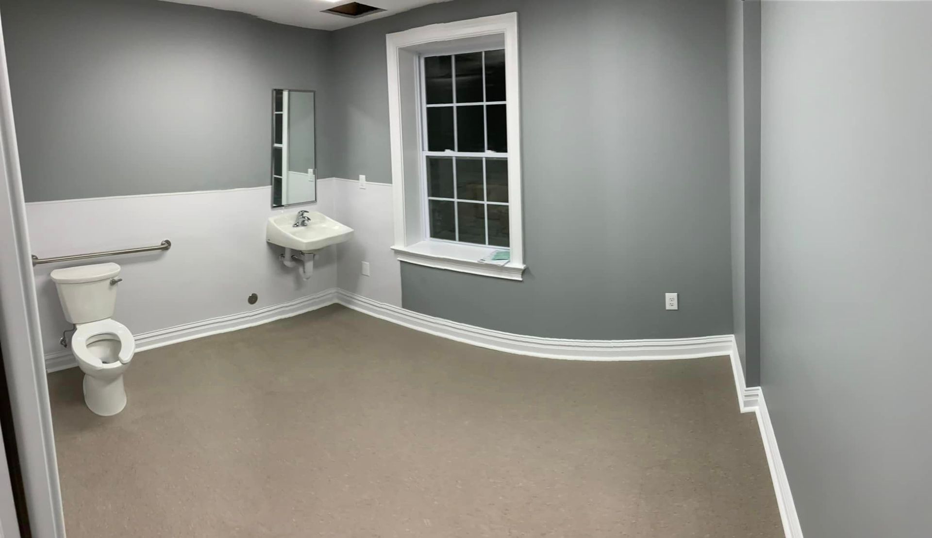 A bathroom with a toilet , sink and window.