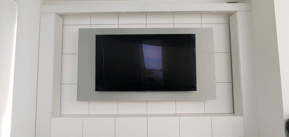 A flat screen tv is mounted on a white wall.