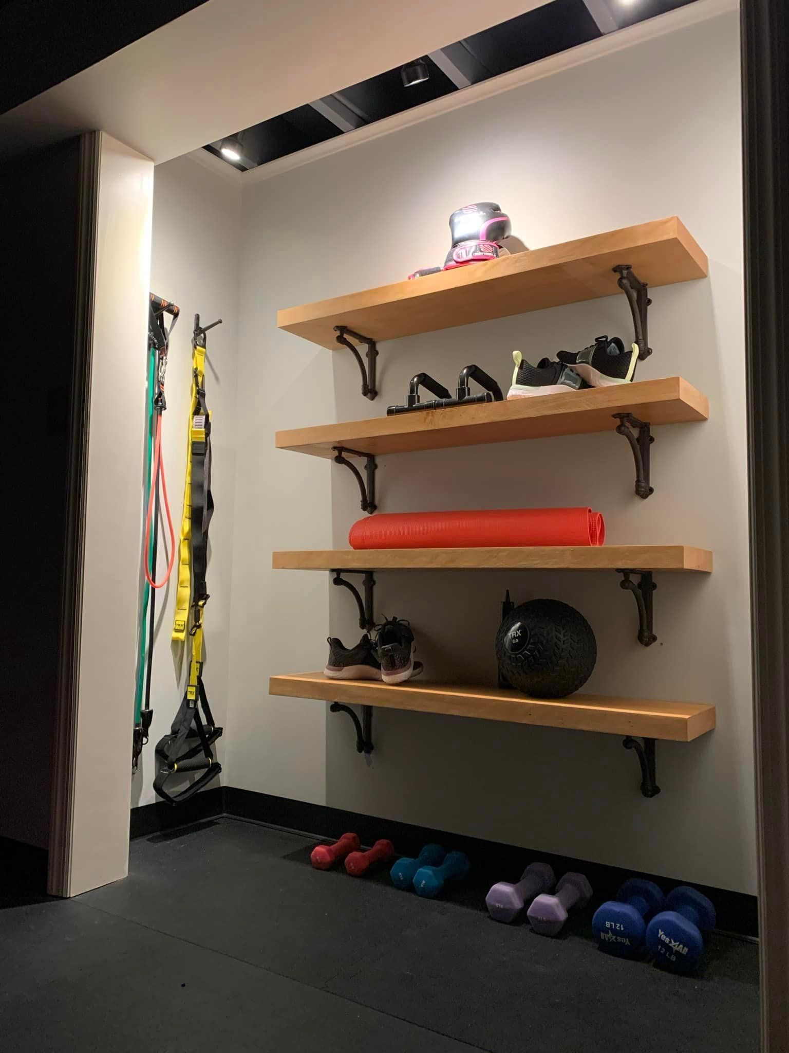 A room with shelves and dumbbells on the floor