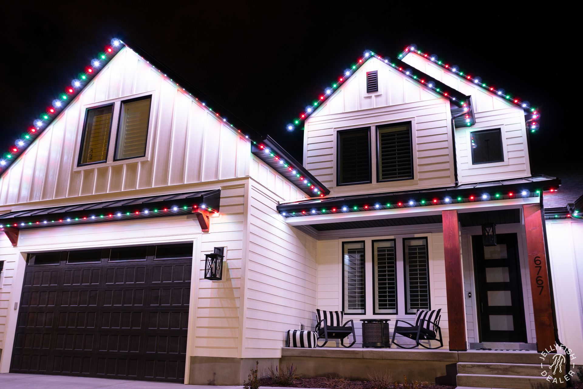 Home with JellyFish Lighting installed along rooflines in multicolor Christmas pattern at night.