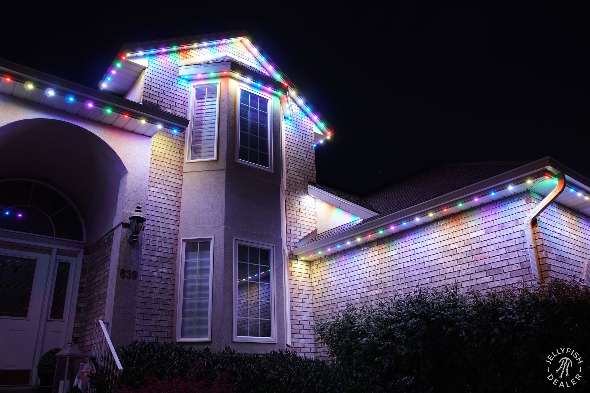 Permanent holiday lighting on a two-story home featuring full-color JellyFish Lighting.