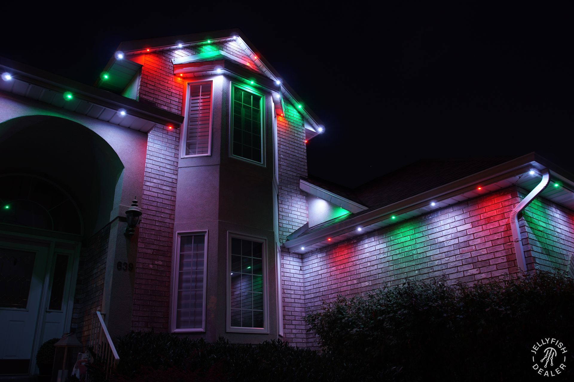 Permanent Christmas lighting with red, green, and white colors installed on a residential home.
